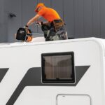 Rv,Technician,Worker,With,Tool,Bag,On,Camper,Roof,Preparing