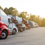 Row,Of,Semi,Trucks,Parked,In,Lot,,Under,A,Clear