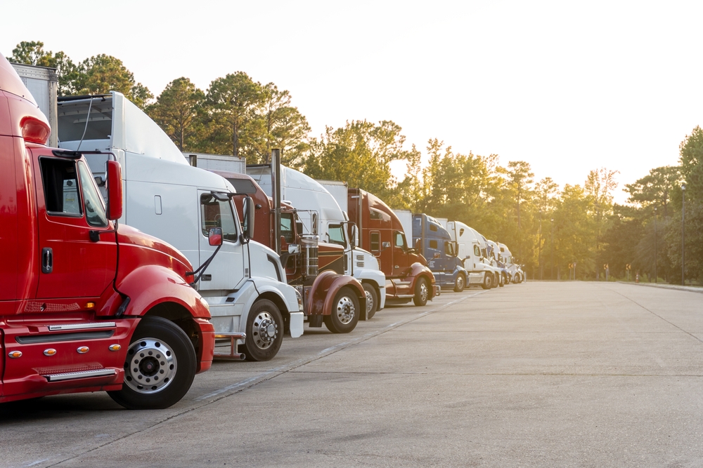 Row,Of,Semi,Trucks,Parked,In,Lot,,Under,A,Clear